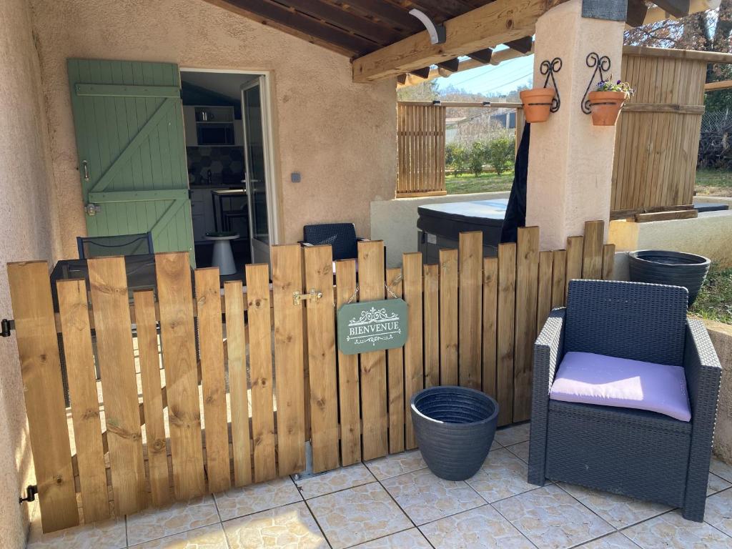 a wooden fence in front of a house at Appartement avec espace jacuzzi et terrasse in Rians