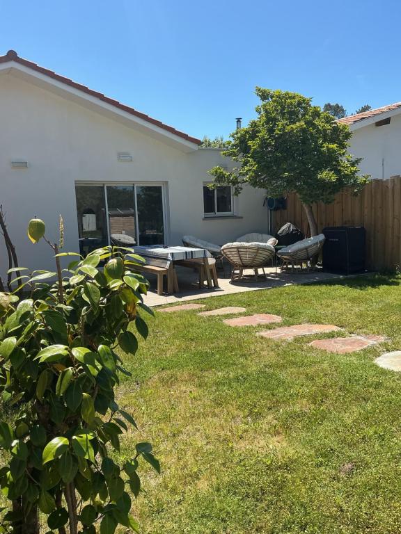 a backyard with a picnic table and a bench at Maison de vacances Helios in Seignosse