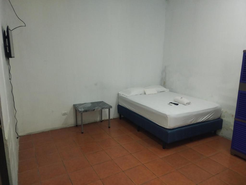 a small bedroom with a bed and a table at Dollar in Liberia