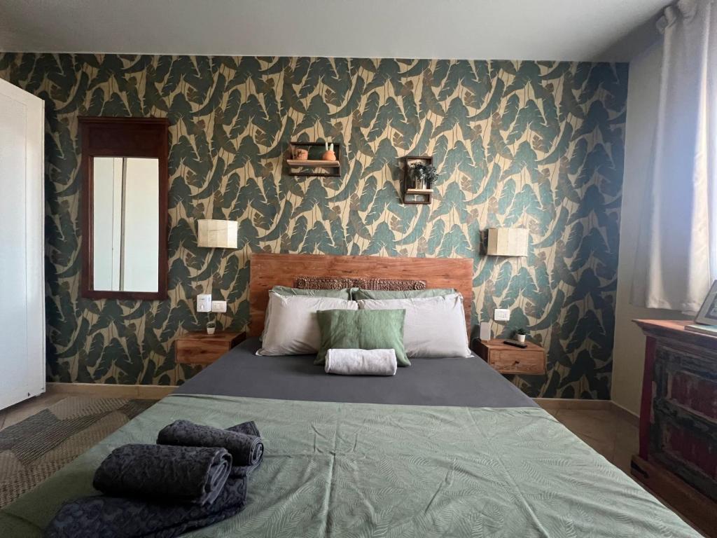 a bedroom with a large bed with a green blanket at Tropical Morabeza Apartment Santa Maria in Santa Maria