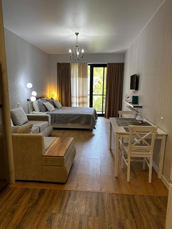 a living room with a couch and a bed and a table at Luxury Residence Likani in Borjomi
