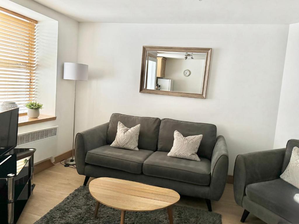 a living room with a couch and a mirror at City Centre House in Inverness