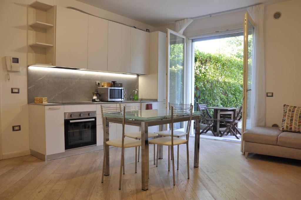 a kitchen with a table and chairs in a room at Appartamento moderno e spazioso con giardino privato in Selvazzano Dentro