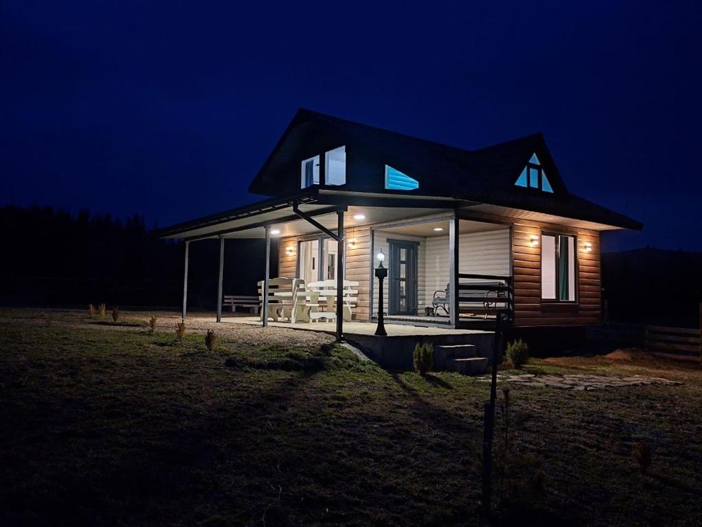 a small house at night with lights on at Bukhouse Carpathians in Krivorovnya