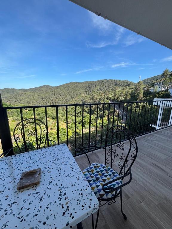 a white table and chairs on a balcony with a view at El Mirador de Espadan in Alcudia de Veo