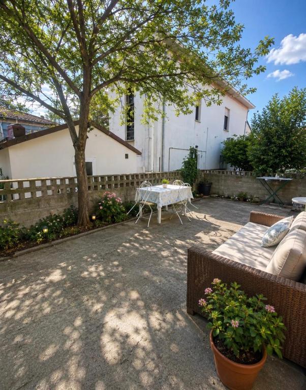 a patio with a table and a tree in a yard at Casa Elisa 8 in Bellaria-Igea Marina