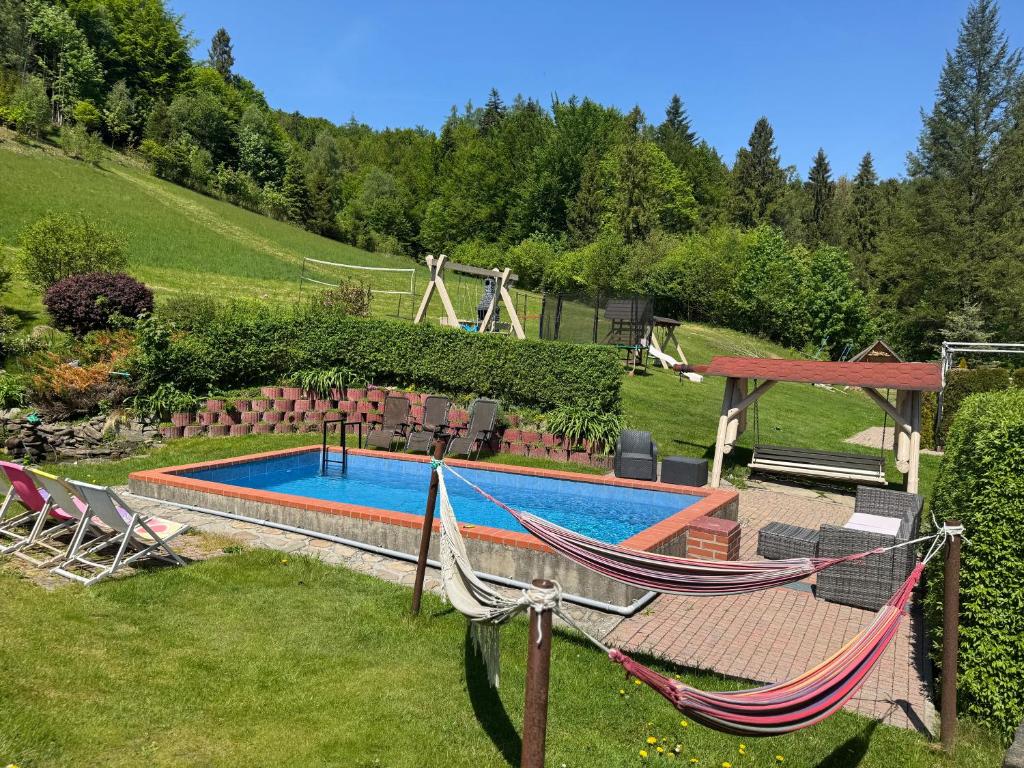 a yard with two hammocks and a swimming pool at Apartamenty Kadłubek in Wisła