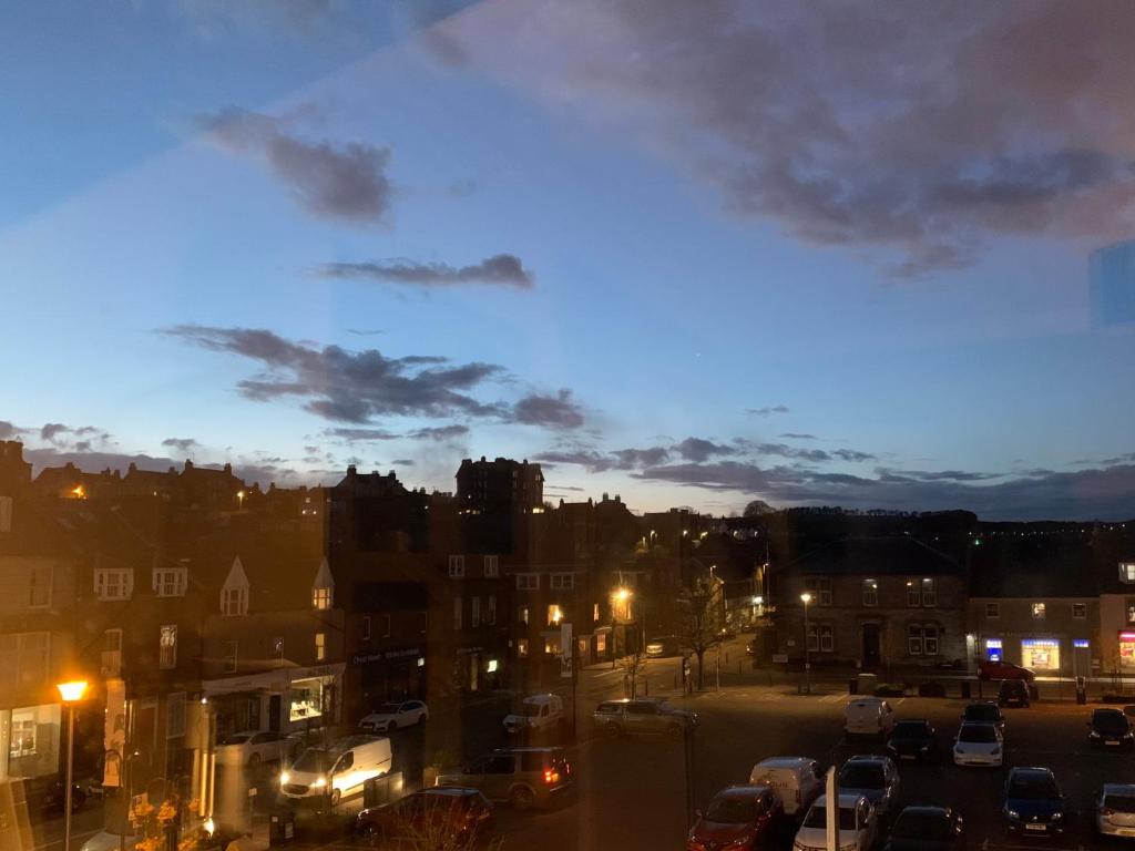 a city at night with cars parked in a parking lot at The Auld Bakehouse in Stonehaven
