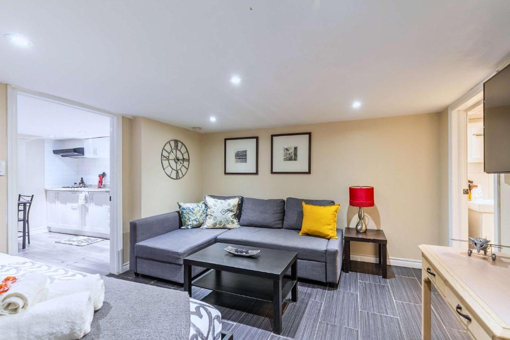 a living room with a blue couch and a table at St Clair Hotel - Cozy Basement Suite with Parking in Toronto