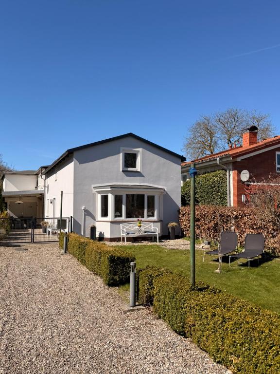 a gray and white house with chairs in a yard at Wohlfühlbude Fehmarn in Fehmarn