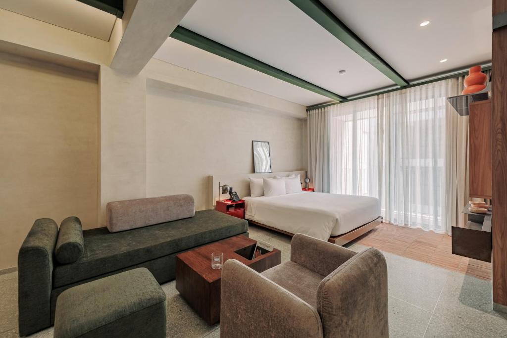 a hotel room with a bed and a couch at Gres Apartments Medellin in Medellín