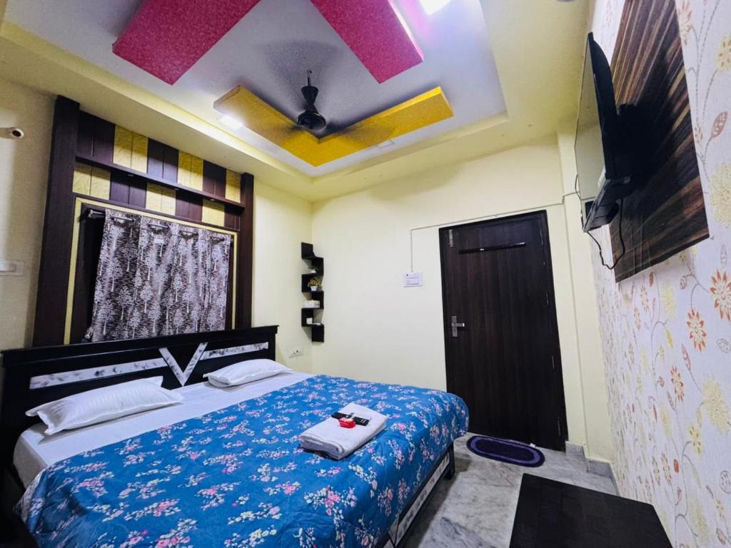 a bedroom with a bed with a ceiling fan at ss luxe inn in Guntūr
