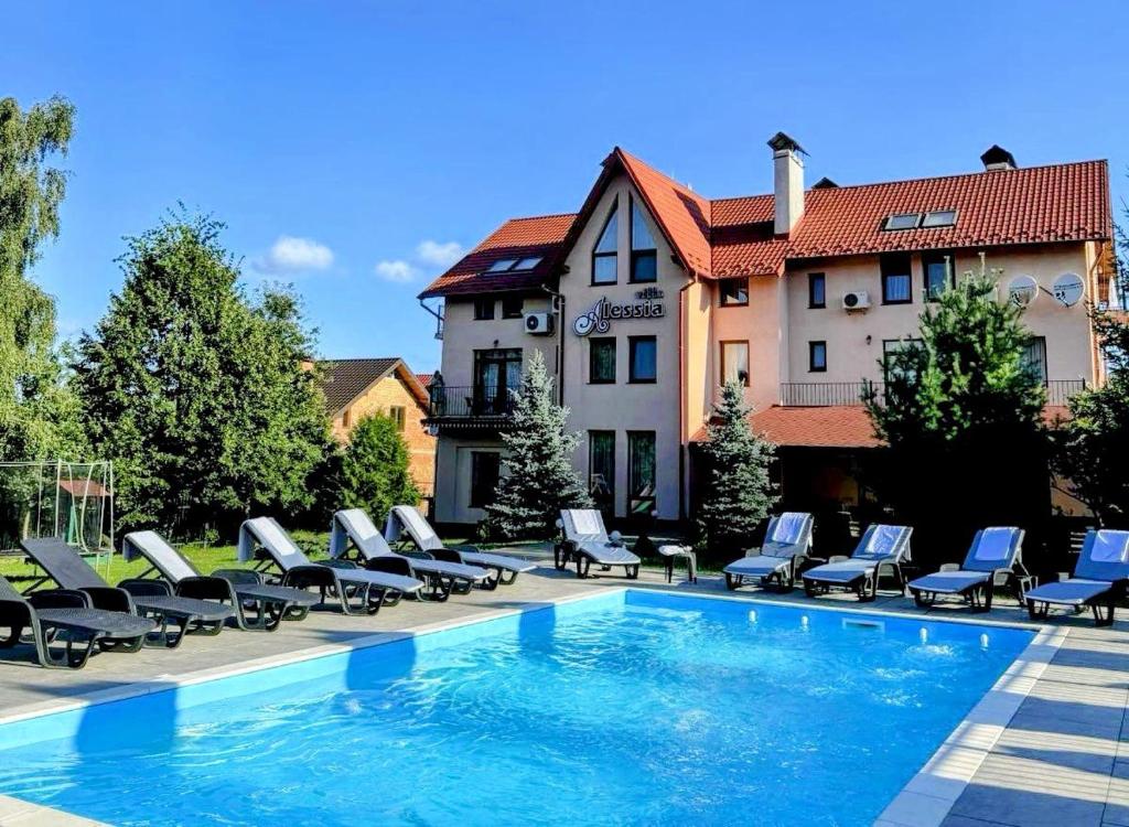 a swimming pool with lounge chairs and a hotel at Villa Alessia in Skhidnitsa