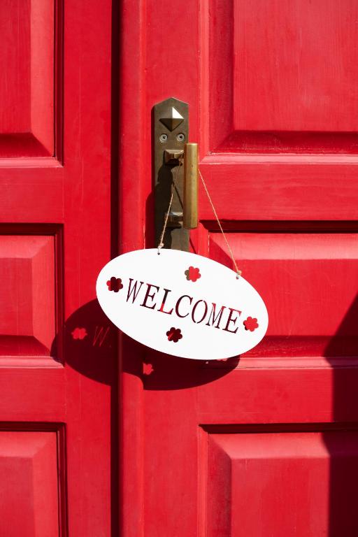 a welcome sign is hanging on a red door at Para, Descansa, Siente el mar - bienvenido a Cullera in Cullera