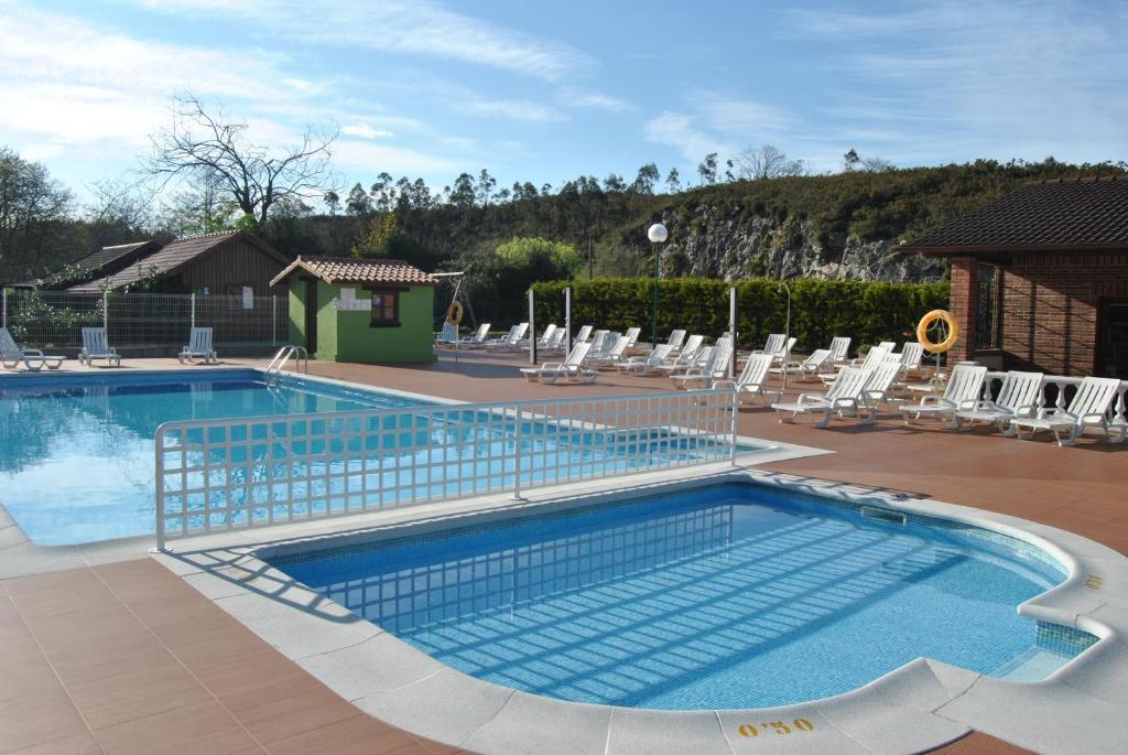 una gran piscina con sillas en Camping Rio Purón, en Llanes