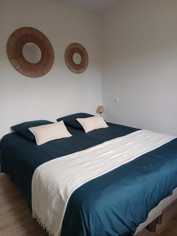 a bedroom with a blue and white bed with two mirrors at Chambre tout confort in Bayeux