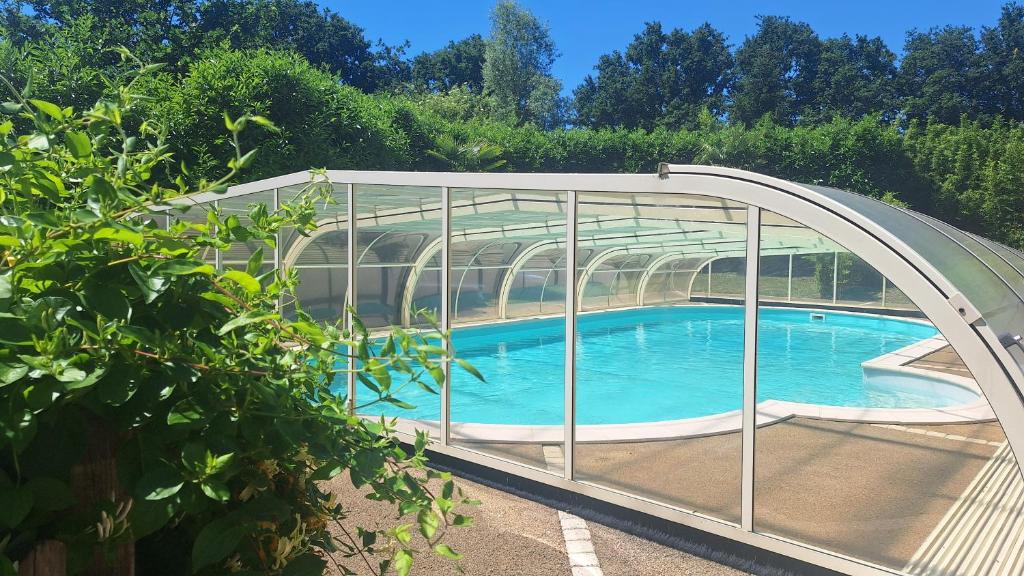a swimming pool under an archway in a garden at Gite de charme avec jaccuzzi privé in Coëx