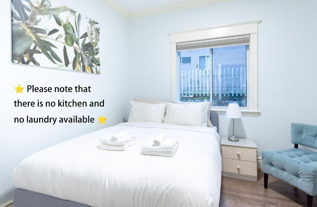 a bedroom with a white bed and a blue chair at 3Beds Ground-Level Private Suite in Burnaby in Burnaby