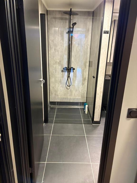 a shower in a bathroom with a tile floor at Wergelandsvegen 40B in Stjoerdal
