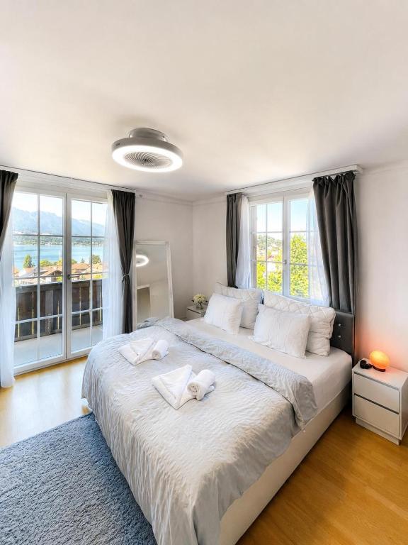 a bedroom with a large bed with two towels on it at Mon Bijou Chalet au Lac Alpin in Thun