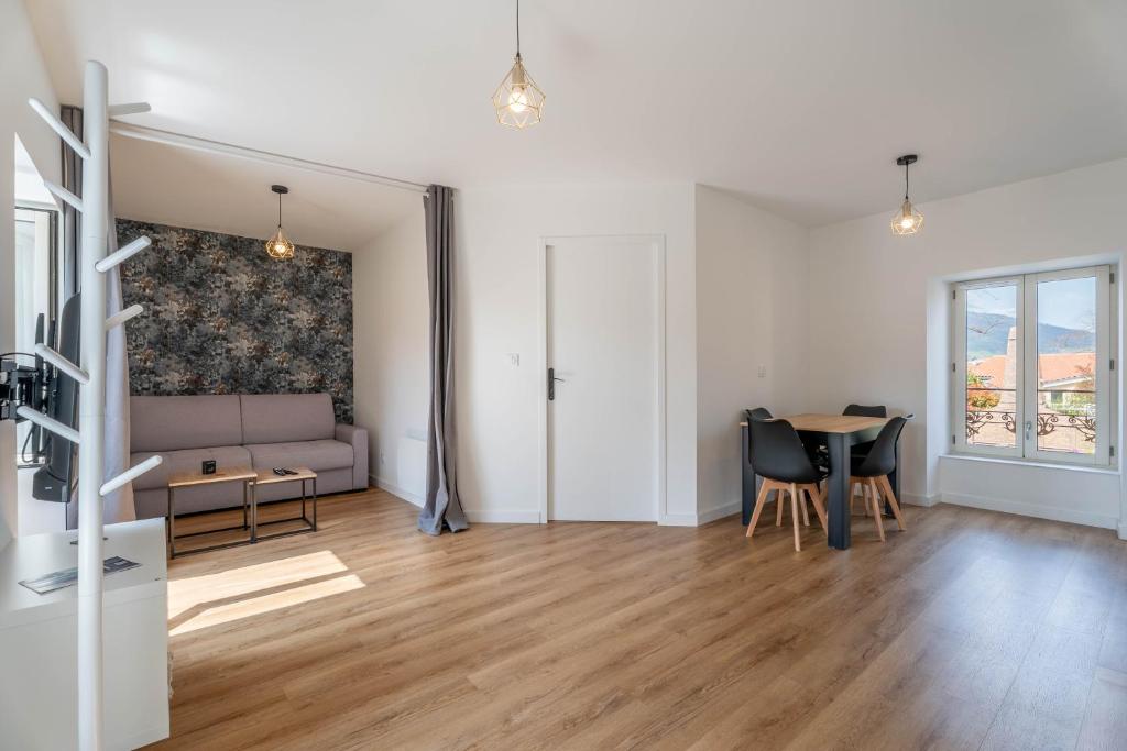 a living room with a couch and a table at Le Saphir By Clem in Pélussin