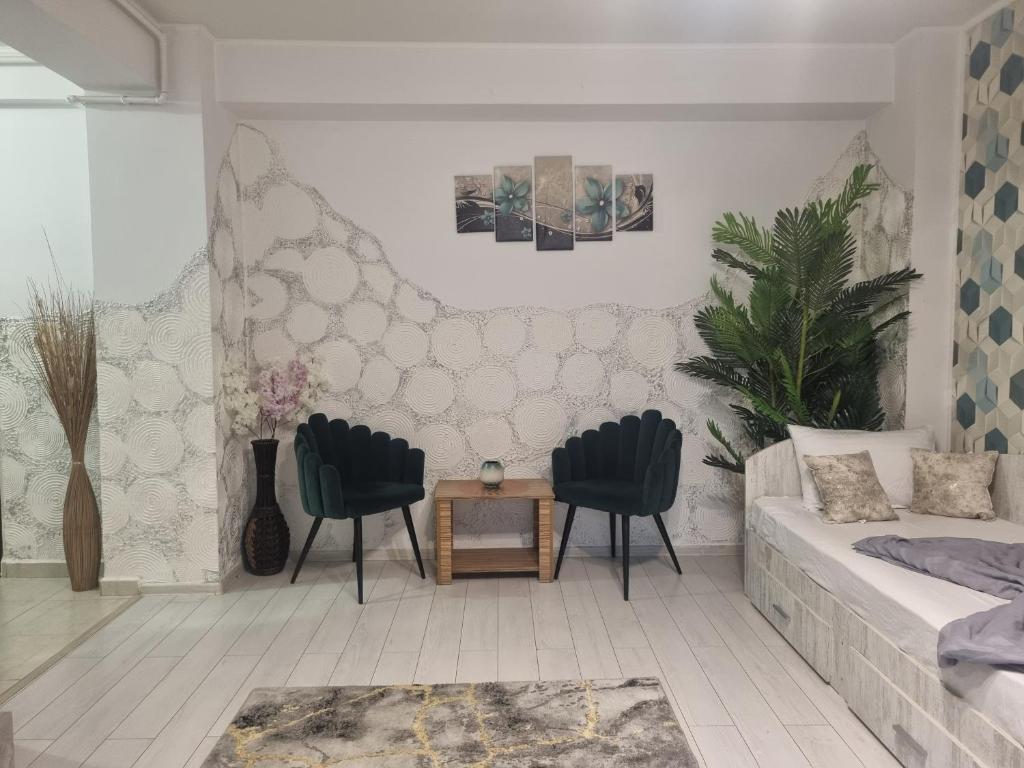 a living room with two chairs and a couch at GOLDEN APARTMENT- Militari Residence Bucharest in Dudu