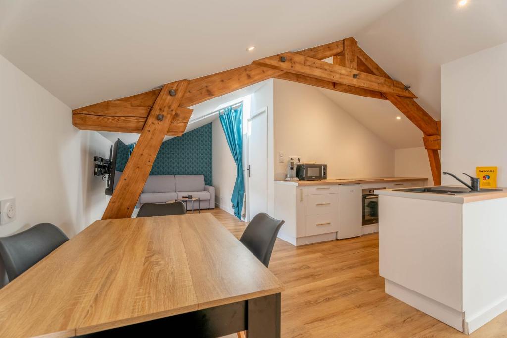 a kitchen and dining room with a wooden table at L'Emeraude By Clem in Pélussin