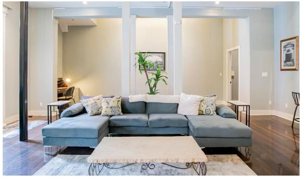 a living room with a blue couch and a table at Downtown Mobile Gem Steps from Cruise & Train Terminals in Mobile