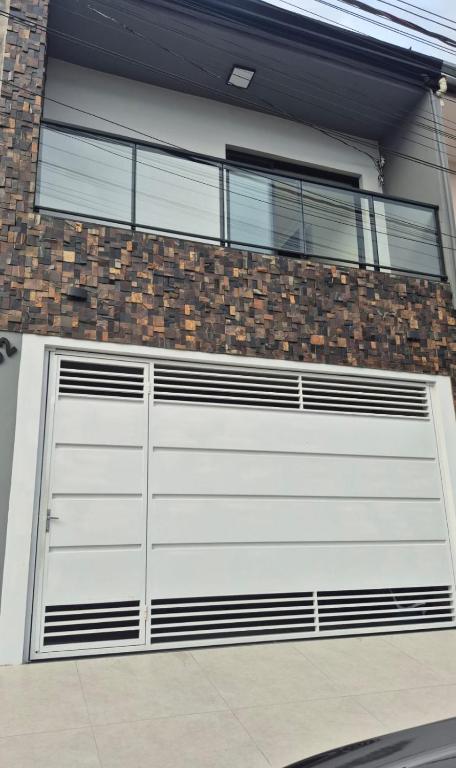 a white garage door on a brick building at Lírio-da-paz in Cachoeira Paulista