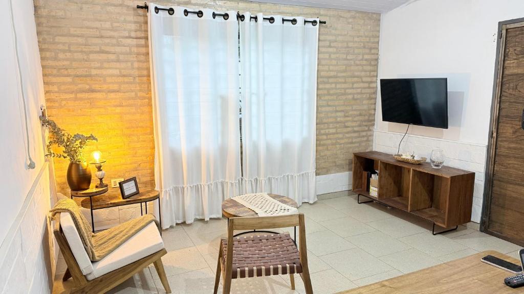 a living room with a large window and a television at Studio Jael Rivera in San Antonio
