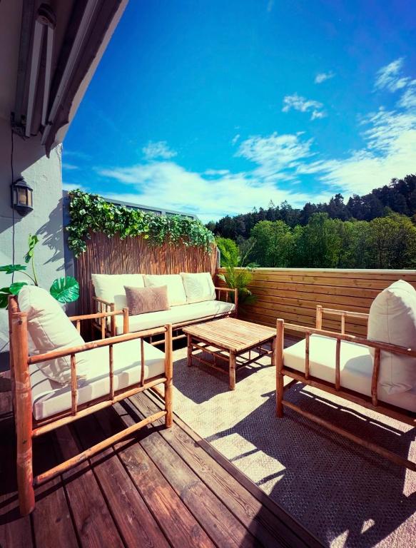 a patio with a couch and a table on a deck at Nordic Retreat Quiet Oasis in Oslo in Oslo
