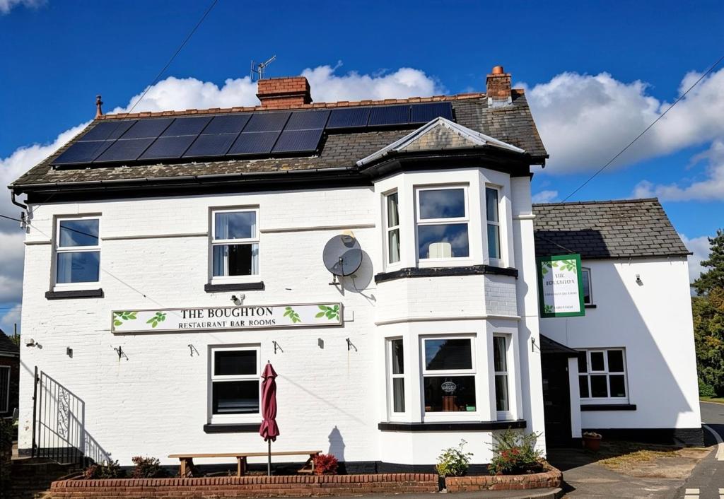 a white building with solar panels on the roof at The Boughton Peterchurch - Pub Grub & Bed in Peterchurch
