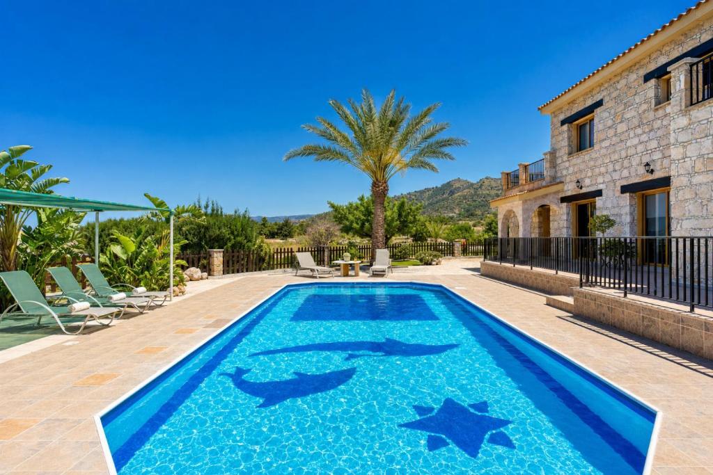 a swimming pool with starfish painted on it in front of a house at Villa Chrisandria in Argaka