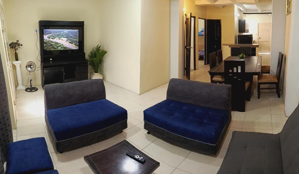a living room with two chairs and a tv at El delfín Santa Elena -Salinas in Santa Elena