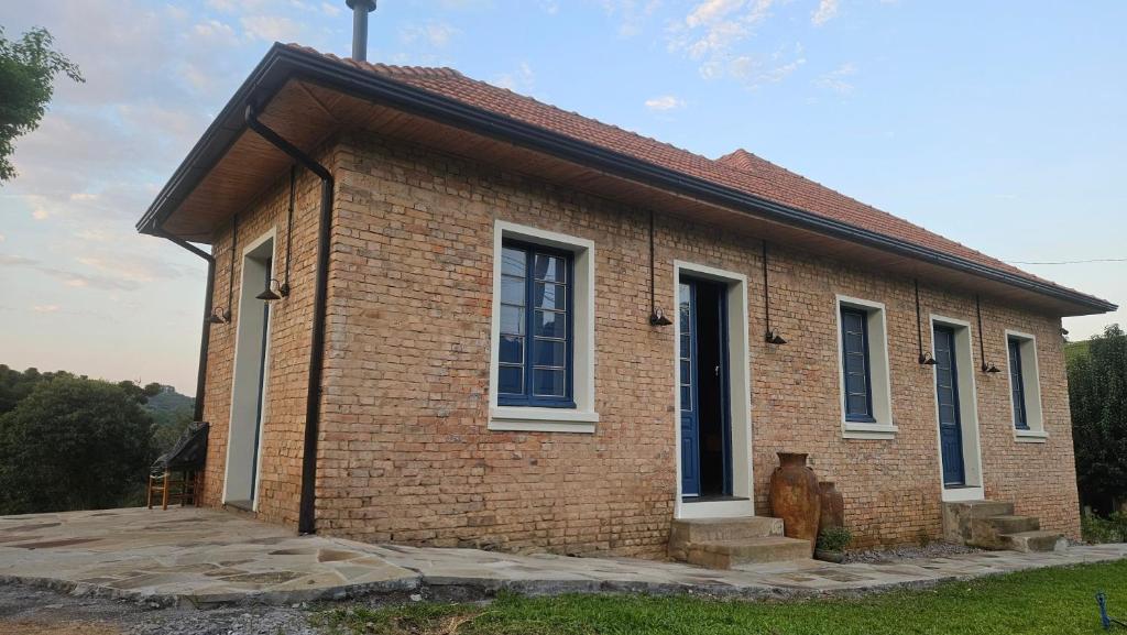 a brick house with a large window on the side at Casa 80 in Monte Belo