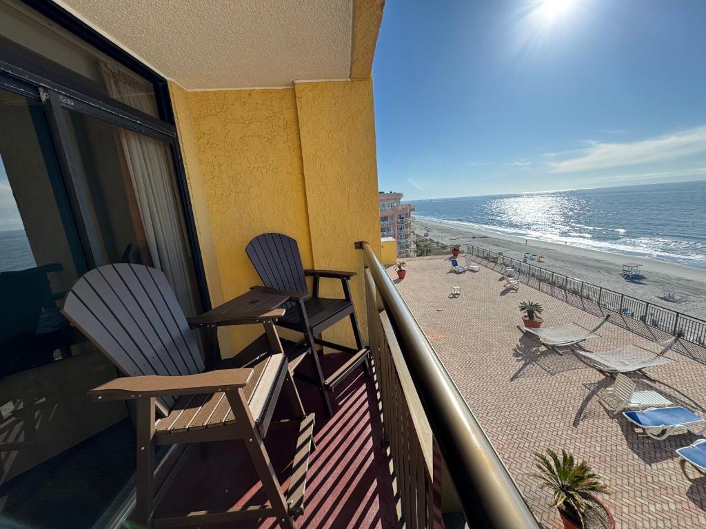 two chairs sitting on a balcony overlooking the beach at Direct oceanfront, separate bedroom condo, 9th floor, unbelievable views! in Myrtle Beach