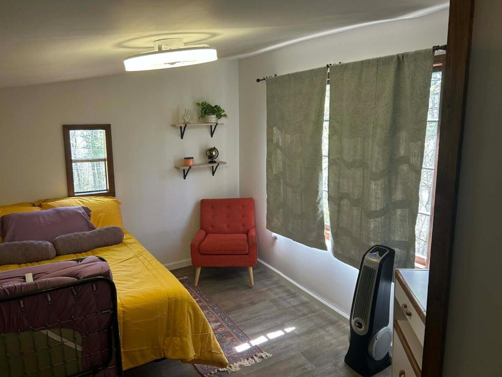 a bedroom with a yellow bed and a red chair at Swift Hollow Timeless Memories in Mountain City