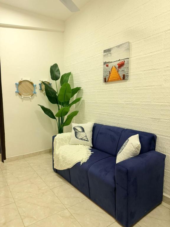 a blue couch in a living room with a plant at GuestHouse Encanto del Centro 4 in Encarnación