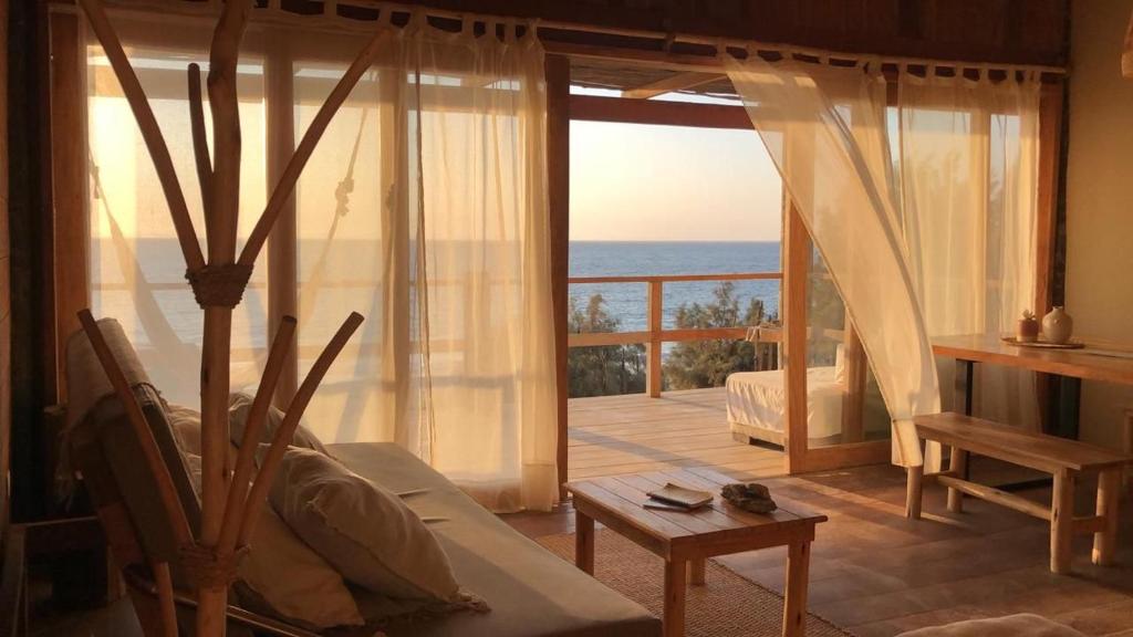 a living room with a view of the ocean at Las tortugas bungalow in Vichayito
