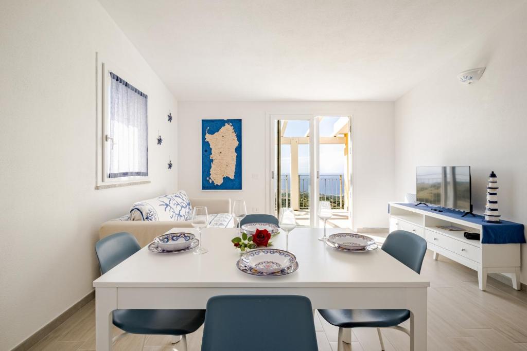 a living room with a white table and chairs at Costa Paradiso Sea View - 8 Guests in Trinità d'Agultu e Vignola