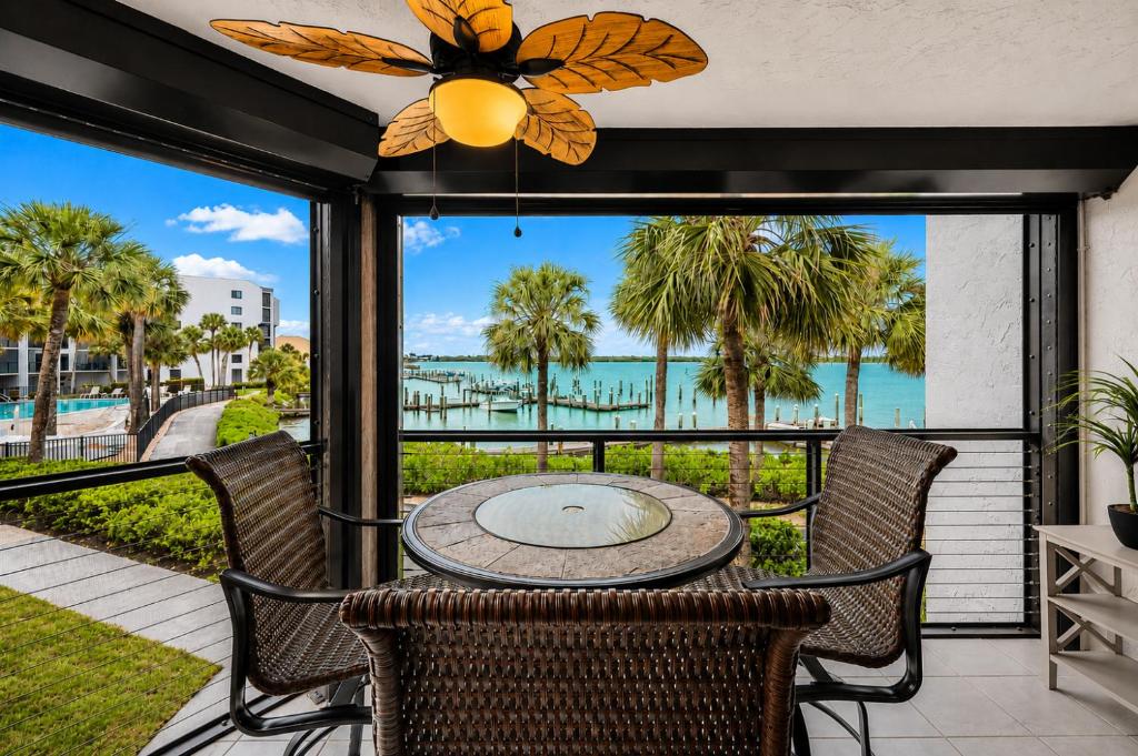 a patio with a table and chairs and a view of the water at Waterfront Island Oasis! Heated Pool with Stunning View & 2 Full Bath in Marco Island