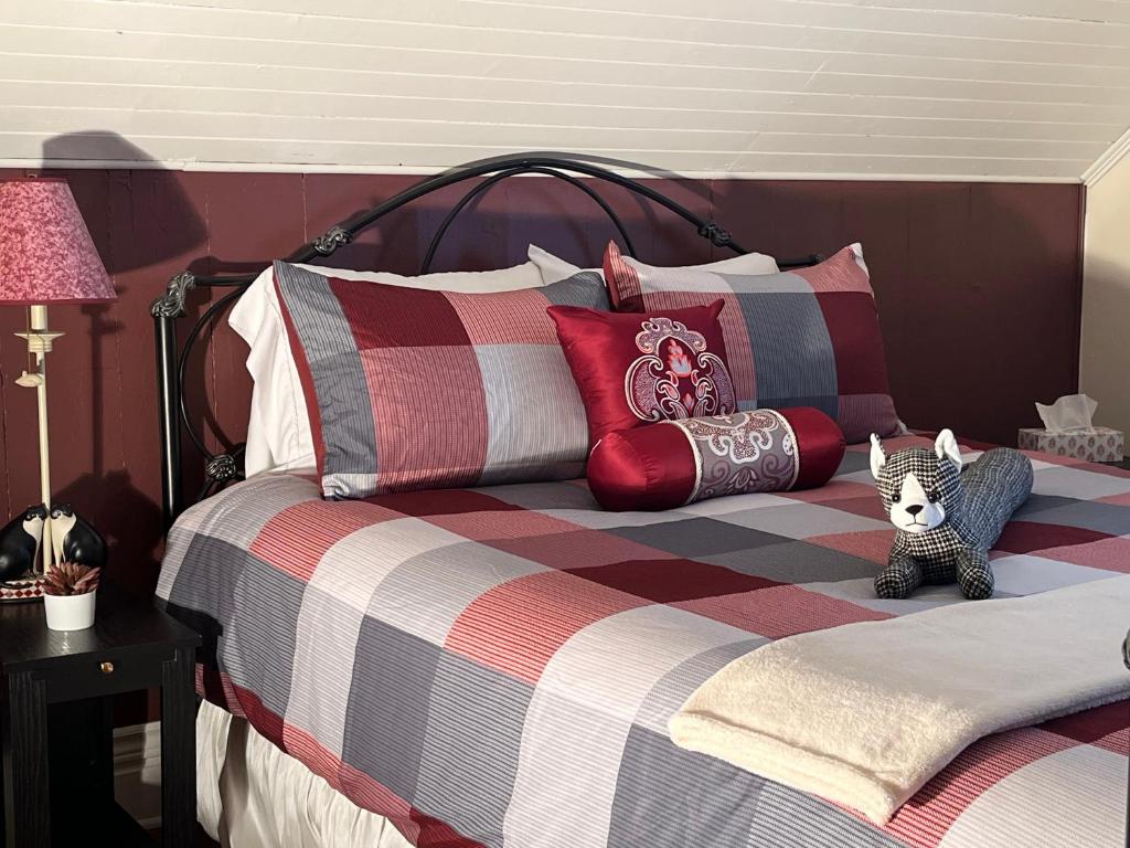a bed with colorful pillows and a stuffed animal on it at La maison du petit rang in Saint-Éloi