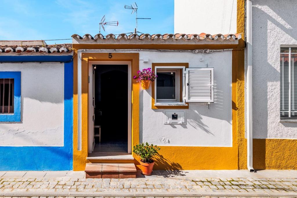 a house with a yellow door and a window at Descanso Alentejano -Casa d'aldeia in Campinho