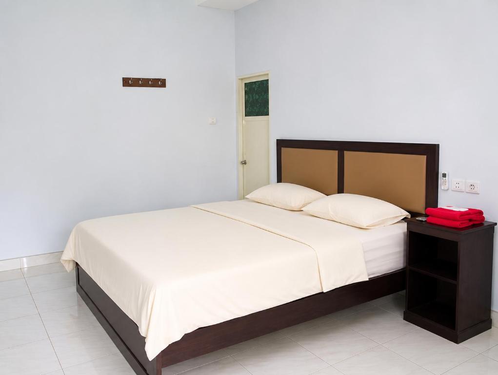 a bedroom with a bed and a red bag on a table at Tanjung Inn in Wonosari
