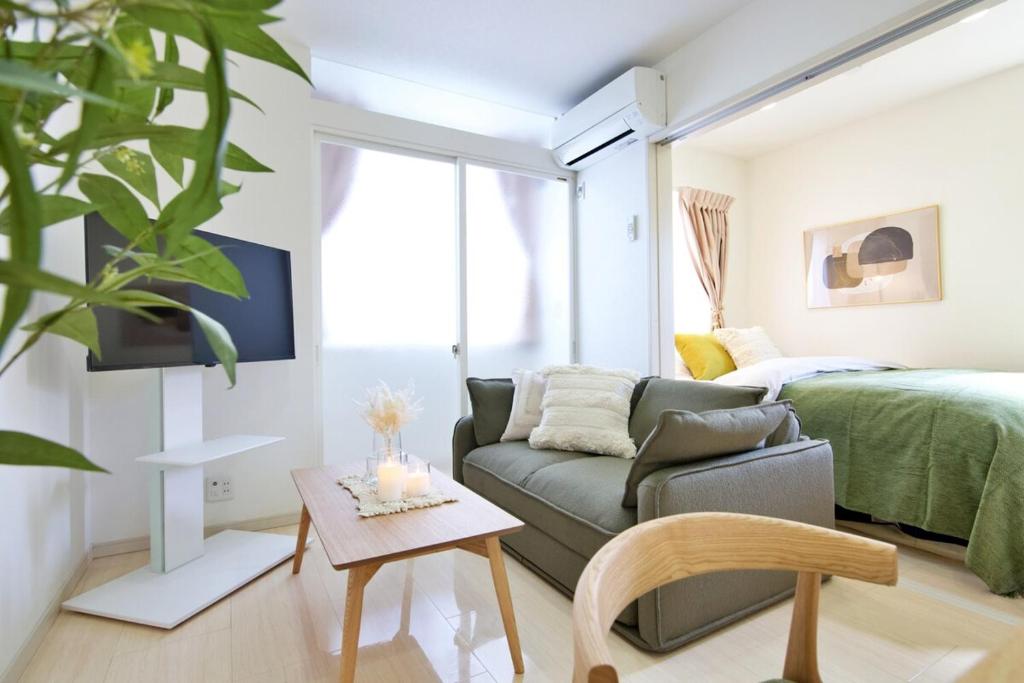 a living room with a couch and a bed at Green Gables A棟 105 in Toyama