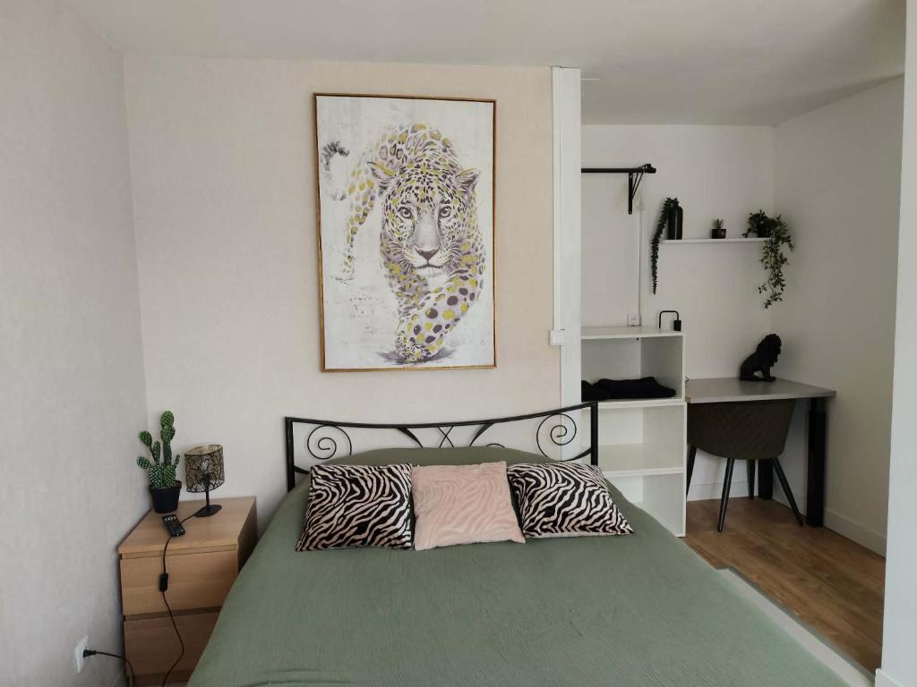 a bedroom with a bed with a zebra picture on the wall at Chambre jungle in Calais