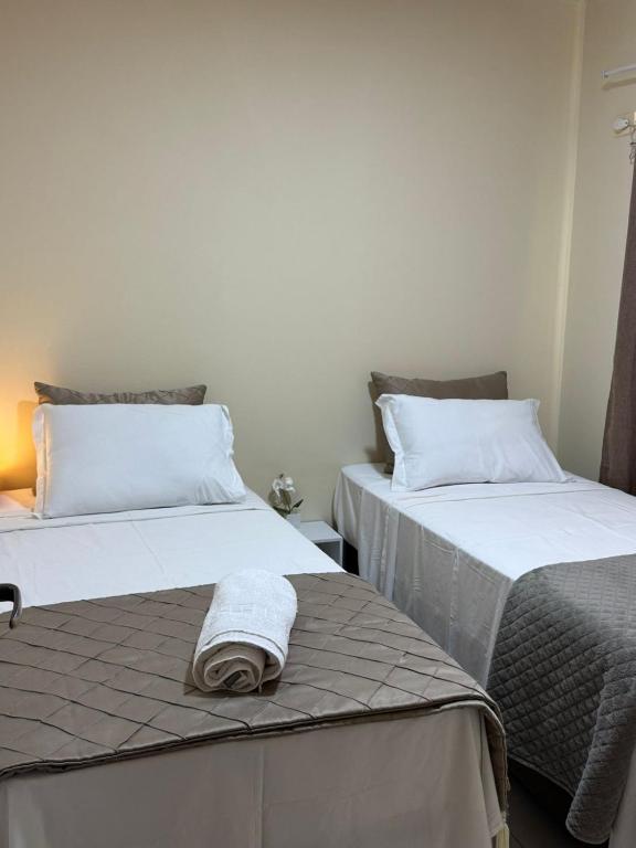 two beds sitting next to each other in a room at Saif Economy Apart in Paranaguá