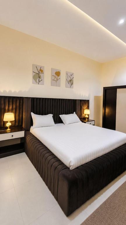 a large bed in a room with two tables and two lamps at وحدات سكنية الشفا in Khamis Mushayt