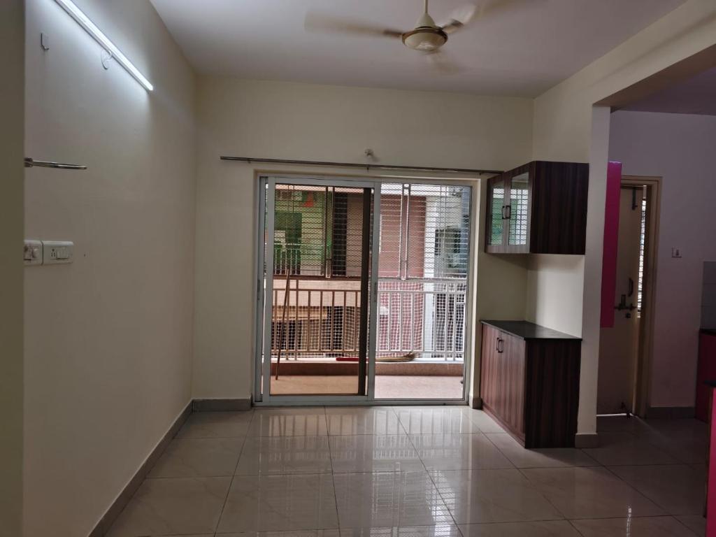an empty room with a door open to a patio at Green fields in Vijayawāda