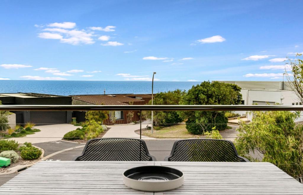 a table on a balcony with a view of the ocean at Ocean Blue View in Capel